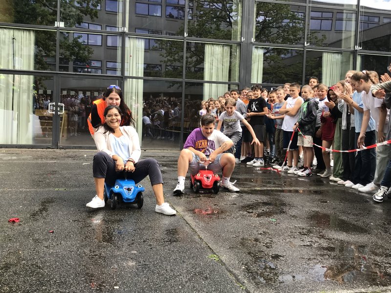 Schüler und Lehrer fahren Bobby Car