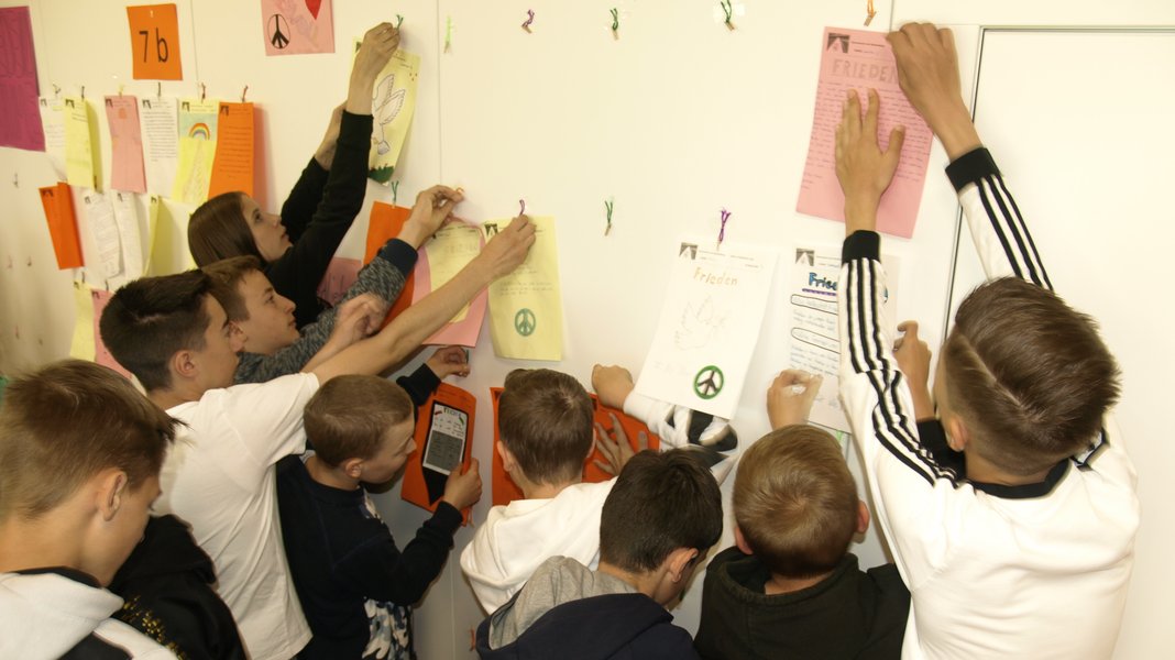 Schüler hängen Plakate auf